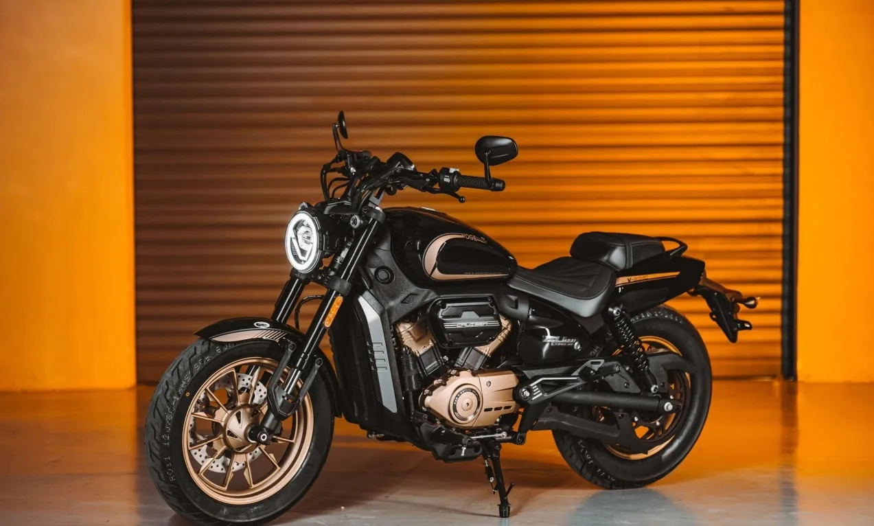 Side view of the Voge CU250 motorcycle parked against an orange wall.