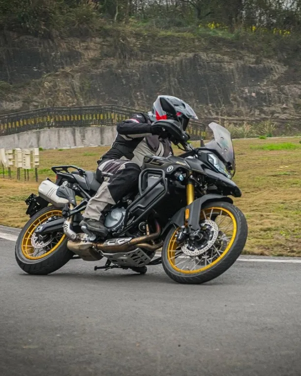 VOGE DS900X in motion on a paved road with mountains in the background