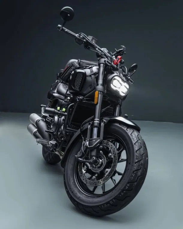 Voge CU525 motorcycle parked outdoors in a natural setting, side view.