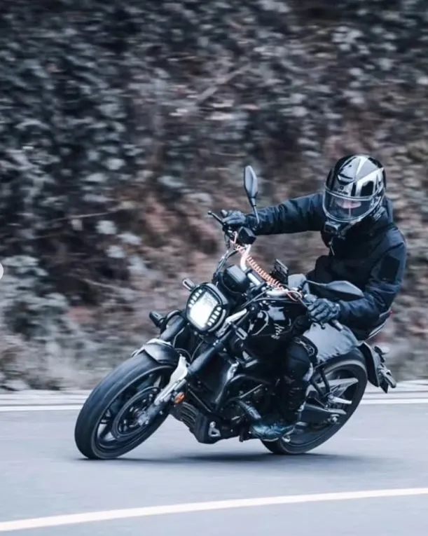 Motorcyclist riding the Voge 300AC in motion on a cold-weather road.