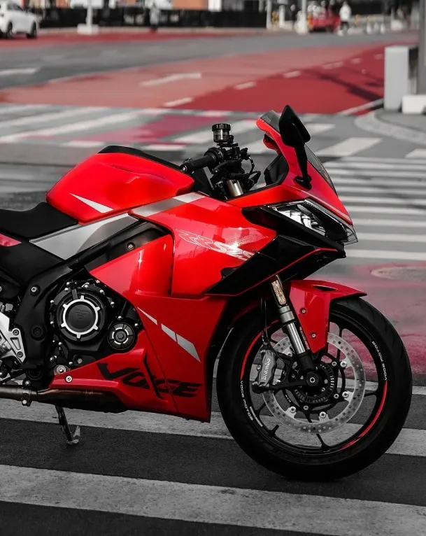 Action shot of the red VOGE 525RR sportbike on an open road, designed for speed.
