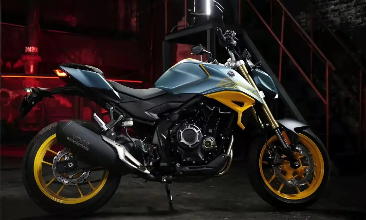 Voge 525R motorcycle parked outdoors at night, side profile emphasizing its aggressive design and yellow wheels.