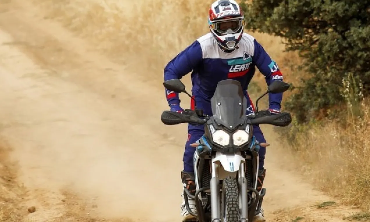Rider in full gear maneuvering the Voge 300 Rally on sandy dirt trails.