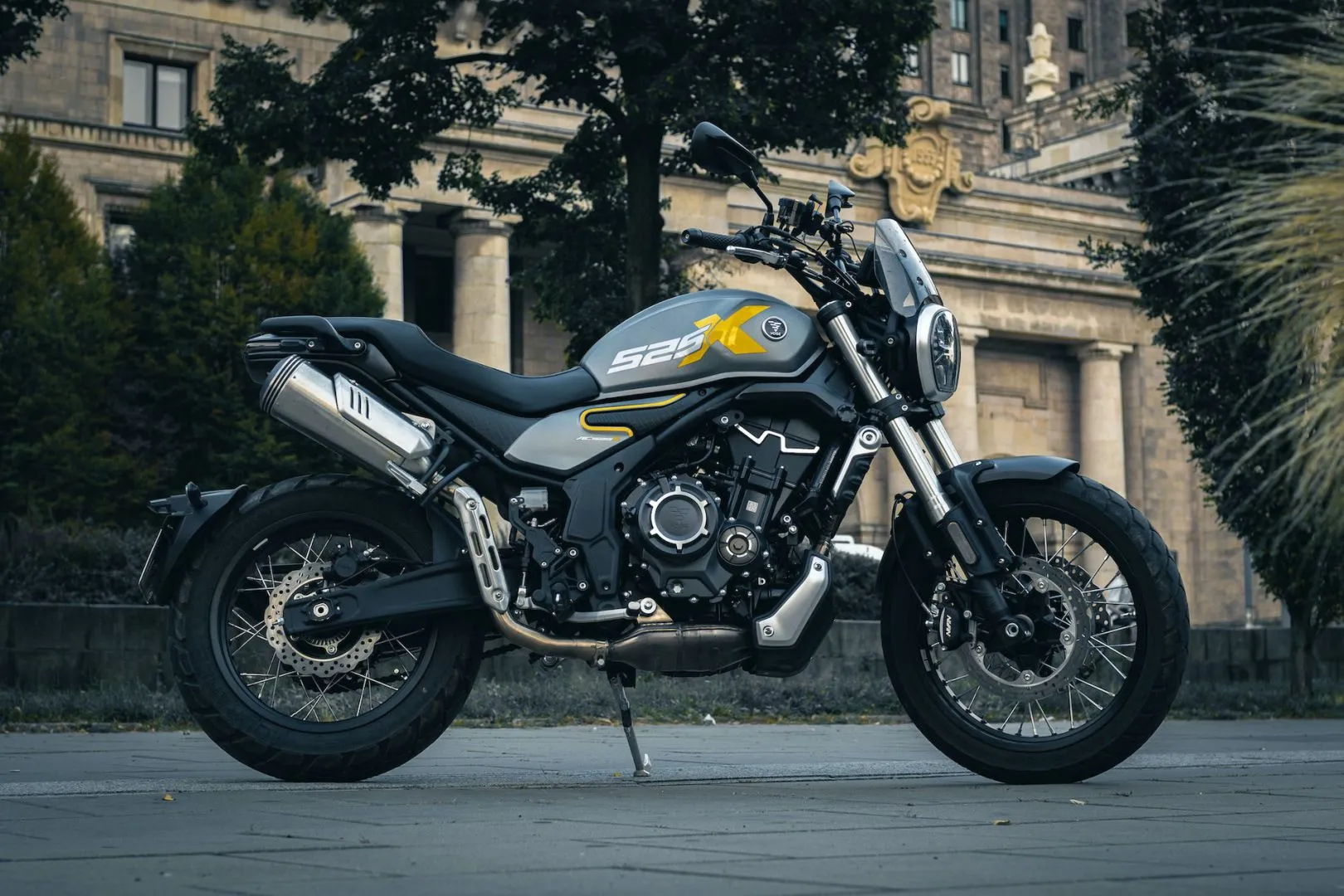 Full side profile of the Voge 525ACX motorcycle parked outdoors, showcasing its yellow X525 branding.