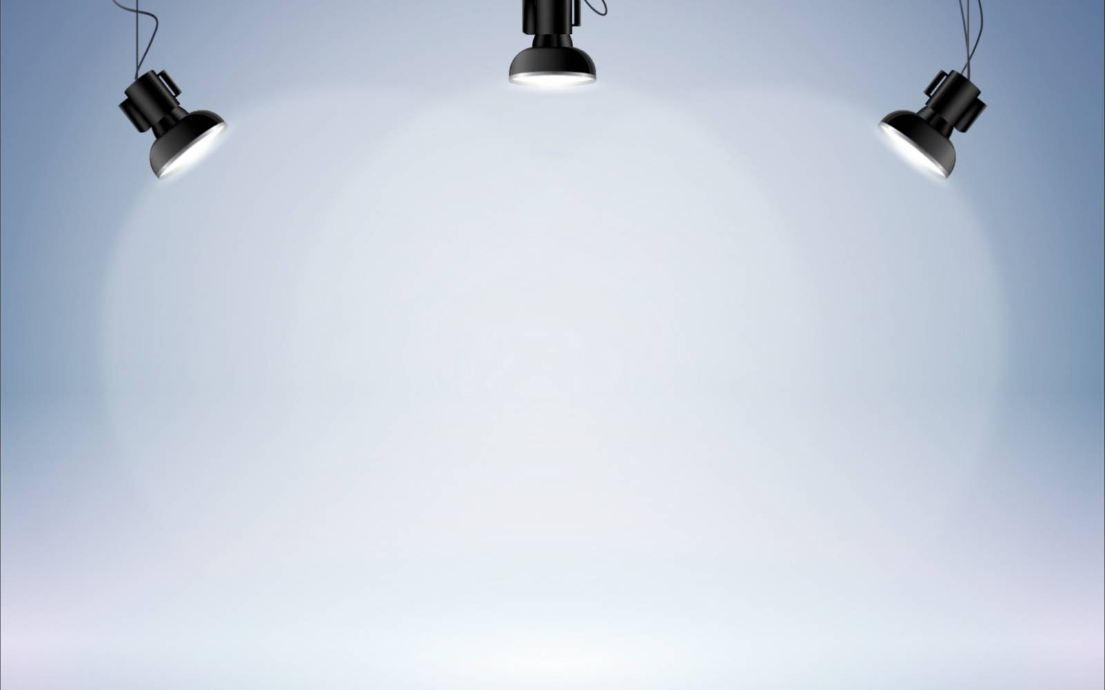 Three studio lights illuminating a blank gray background