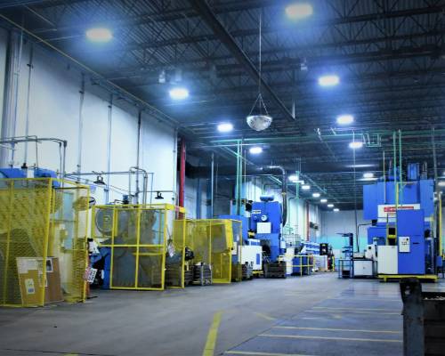 Industrial warehouse interior with yellow safety barriers and blue machinery