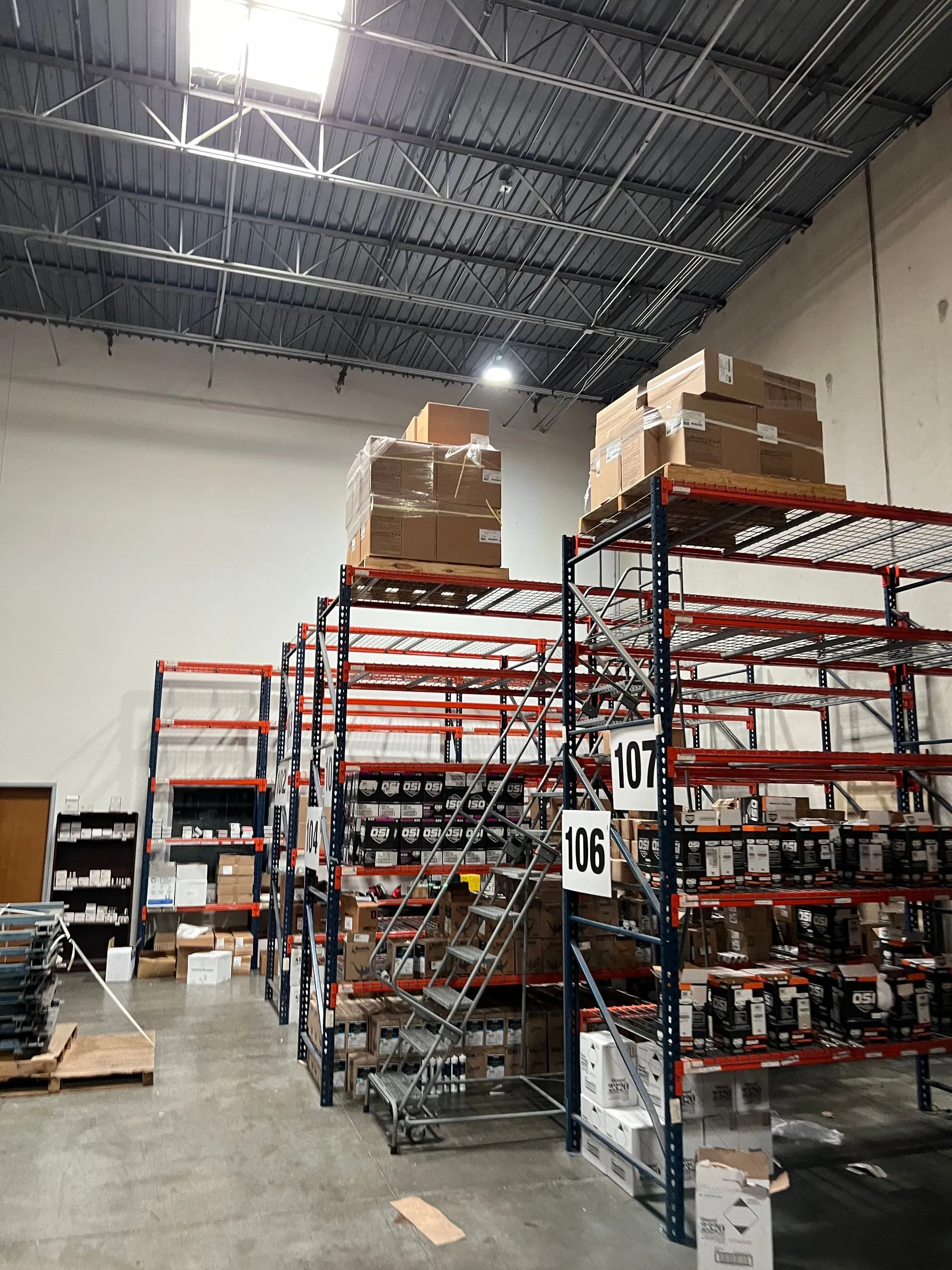 Warehouse interior with tall shelving, stacked boxes, and industrial metal racking