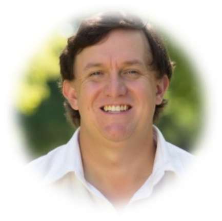 Smiling middle-aged man in white shirt against blurred green background