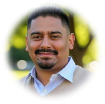 Smiling man in white shirt with blurred green background