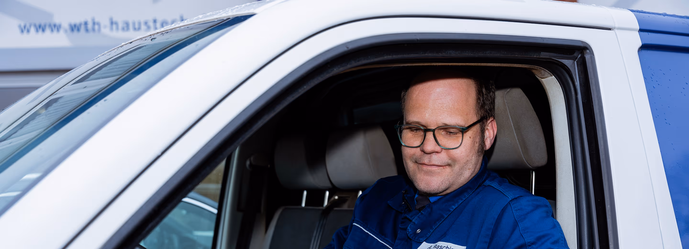 Mitarbeiter von wth in seinem Firmenwagen sitzen 