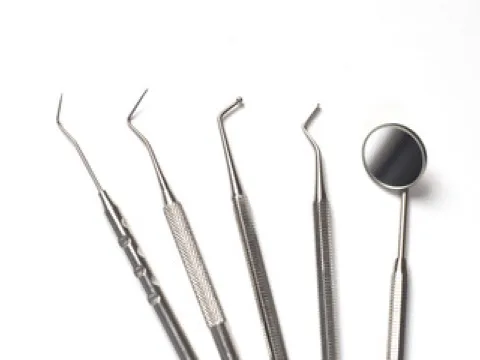 A group of dental tools sitting on top of a white table.