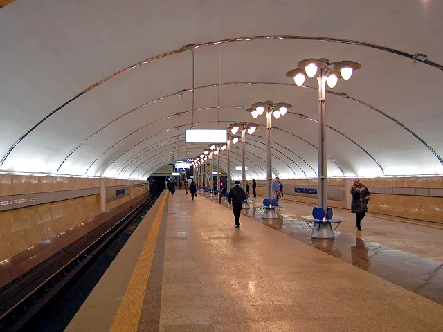 A group of people walking down a train platform.