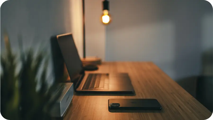 Un ordinateur et un téléphone portable sur un bureau en bois