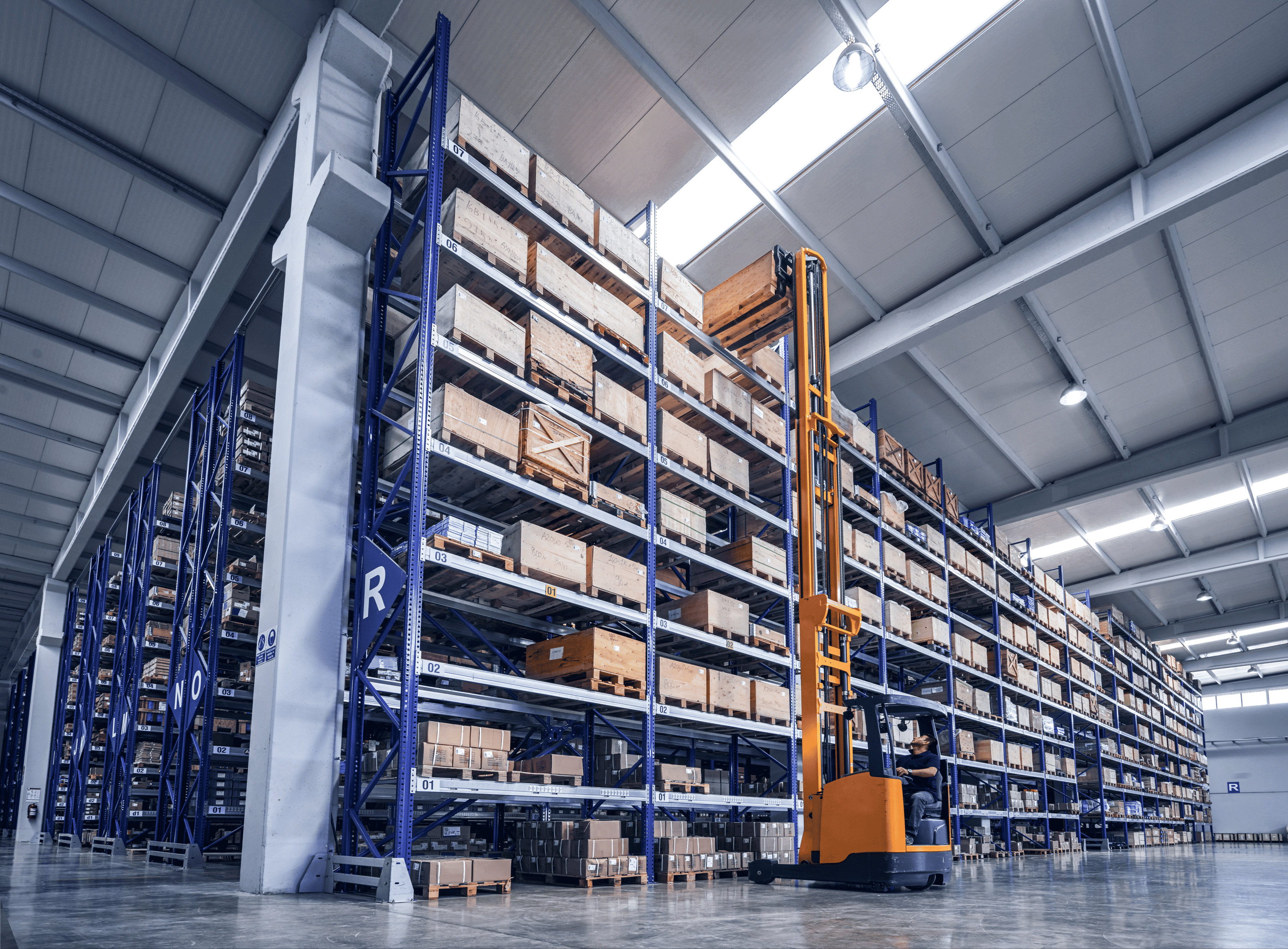High‑bay warehouse with pallet racking and material handling equipment illustrating coordinated warehouse operations and efficient order processing.