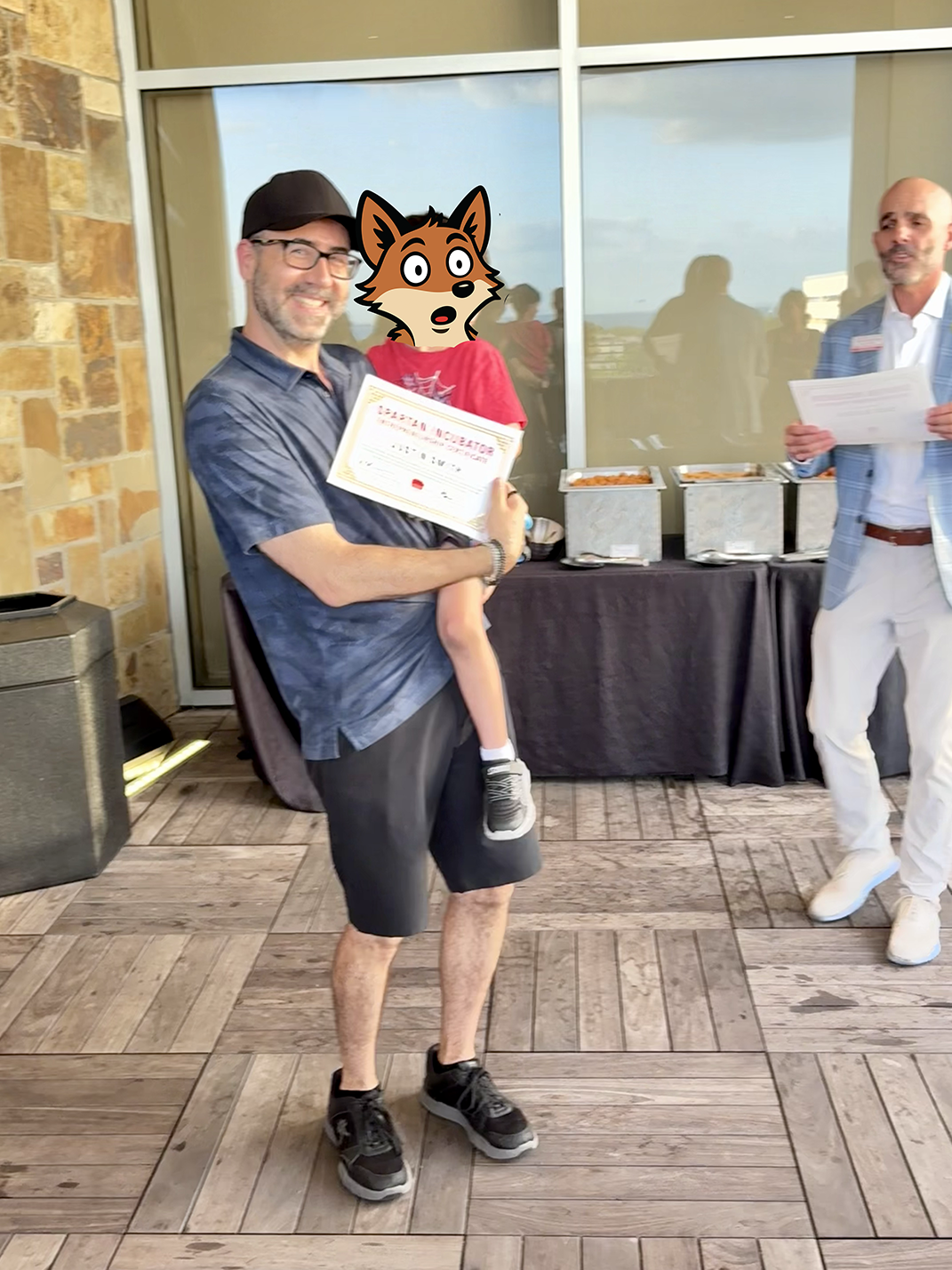 Cray founder Justin Smith, holding his son (face covered by the Cray fox mascot), accepts his Spartan Incubator certificate at the University of Tampa's Lowth Entrepreneurship Center celebration