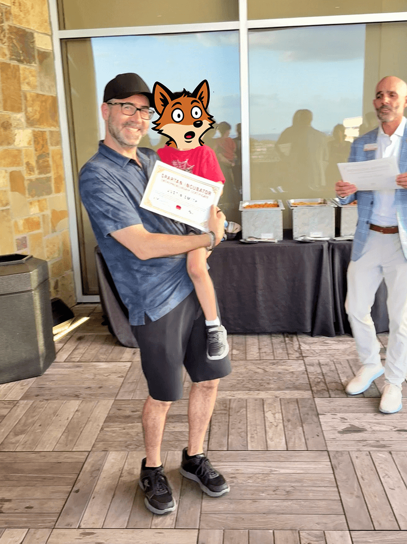 Justin Smith holding his Spartan Incubator certificate at the University of Tampa