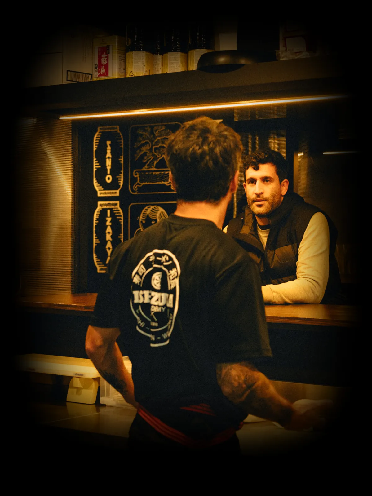 Chef e cliente à conversa ao balcão do Santo Izakaya