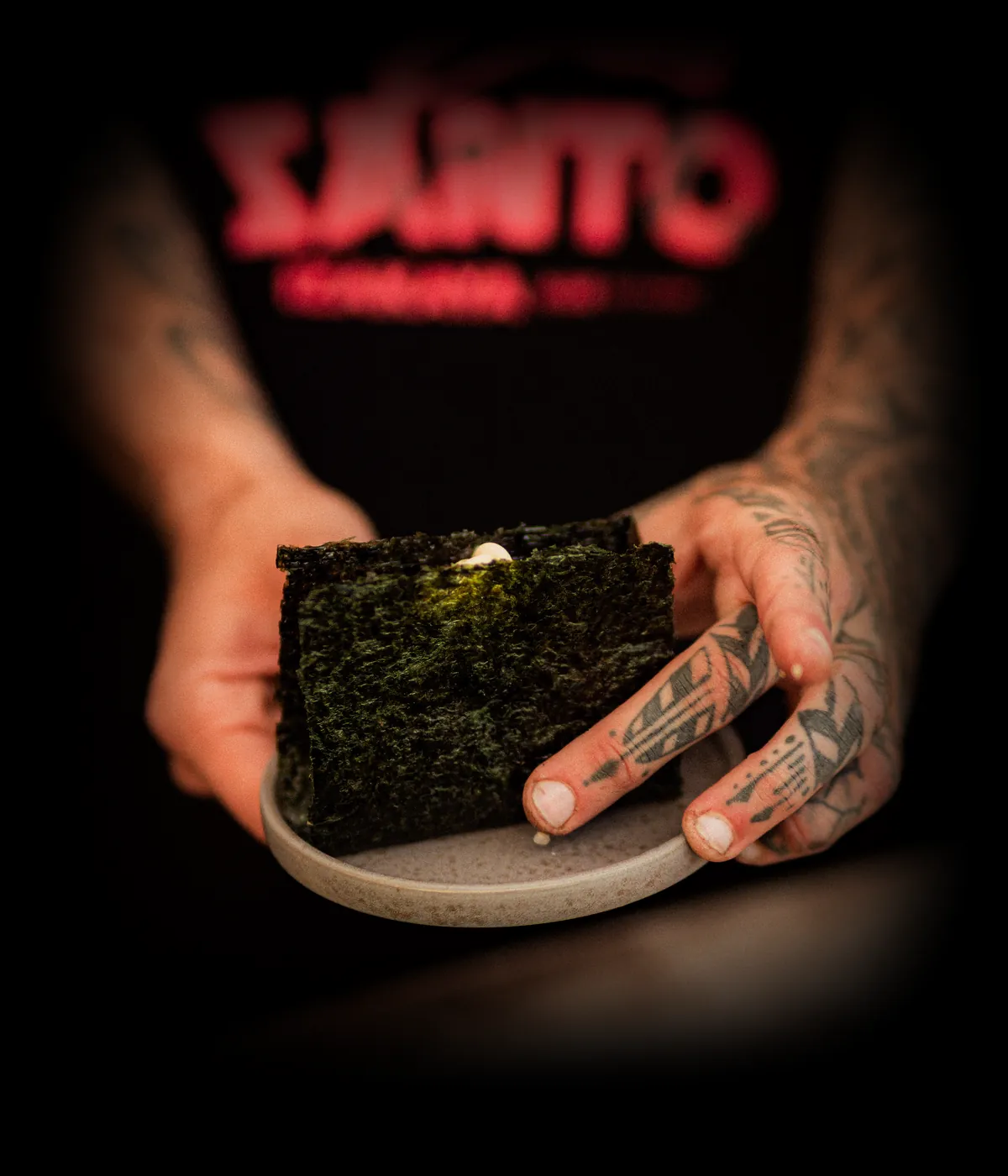 Onigiri servido por um chef com a t-shirt do Santo Izakaya