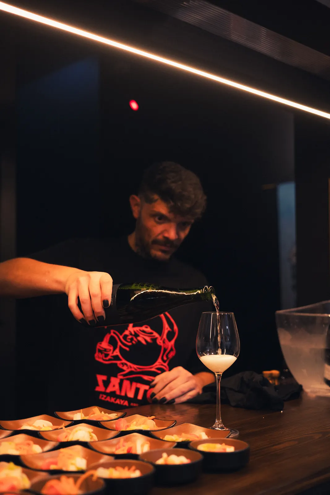 Bartender do Santo a servir ao balcão escuro