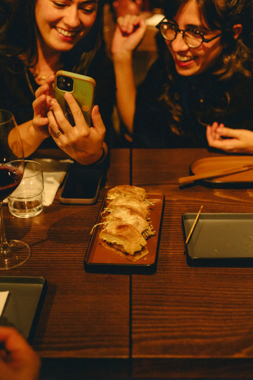 Duas amigas a rir à mesa