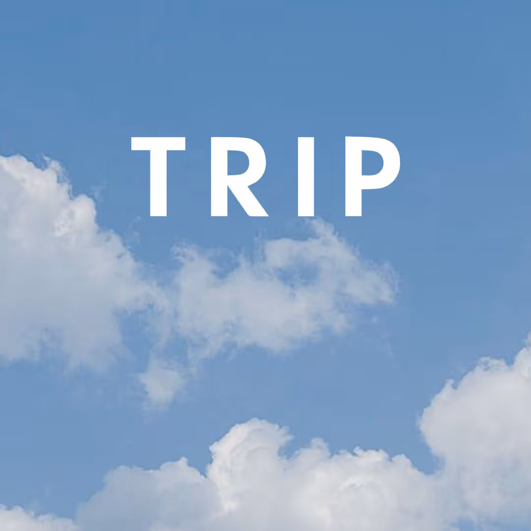 White uppercase letters spelling TRIP over a blue sky with scattered white clouds.