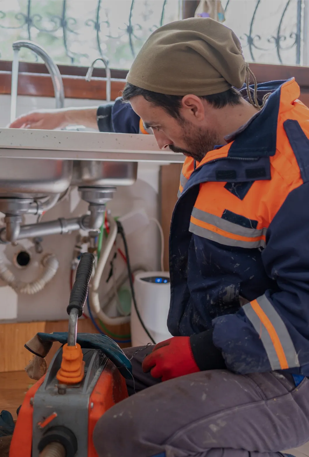 A plumber using tools to check the pipe leakage