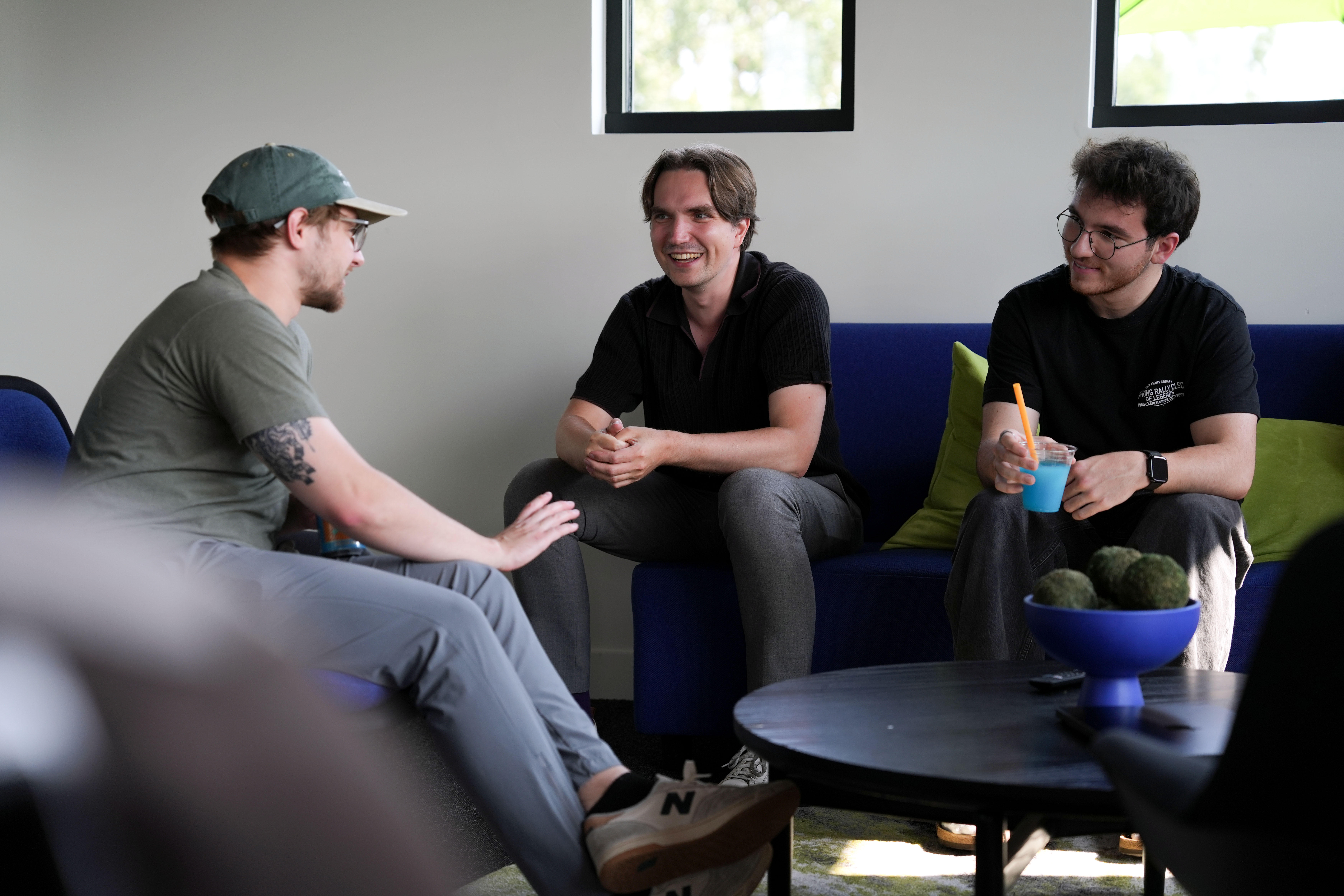 Stas Burikhin smiling and conversing with coworkers in the Ada office lounge space.