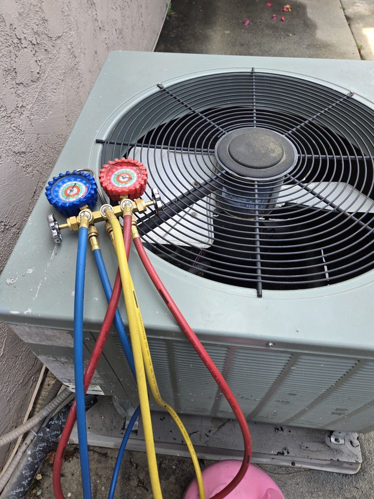 AC unit being checked with refrigerant gauges attached to the service ports.