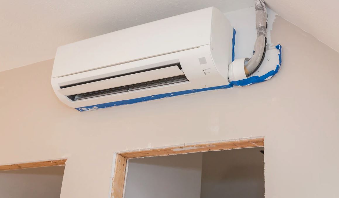 Wall-mounted ductless mini-split AC unit installed above a doorway.