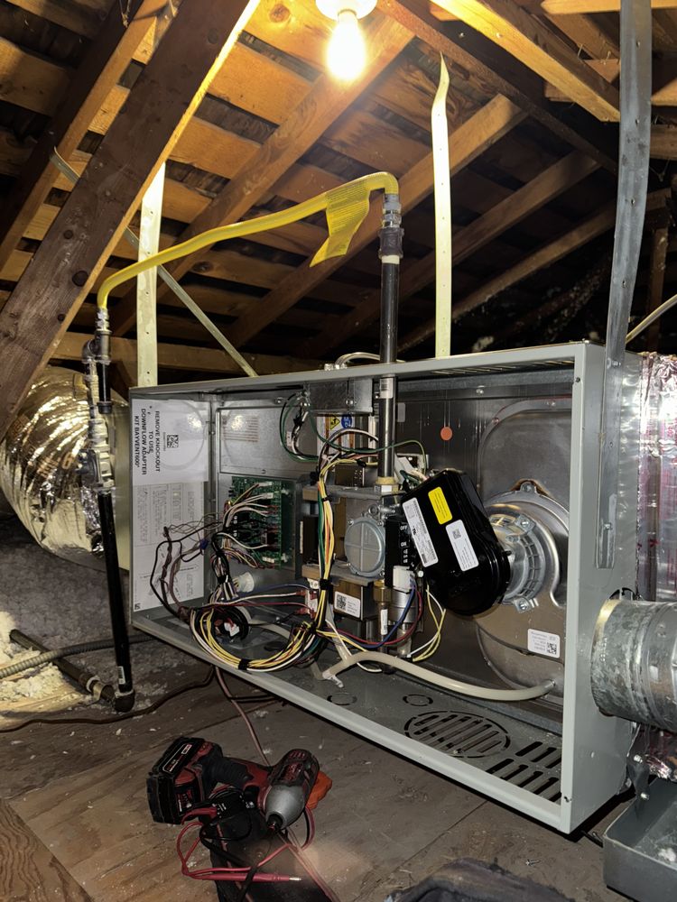 Open furnace unit in an attic with exposed wiring