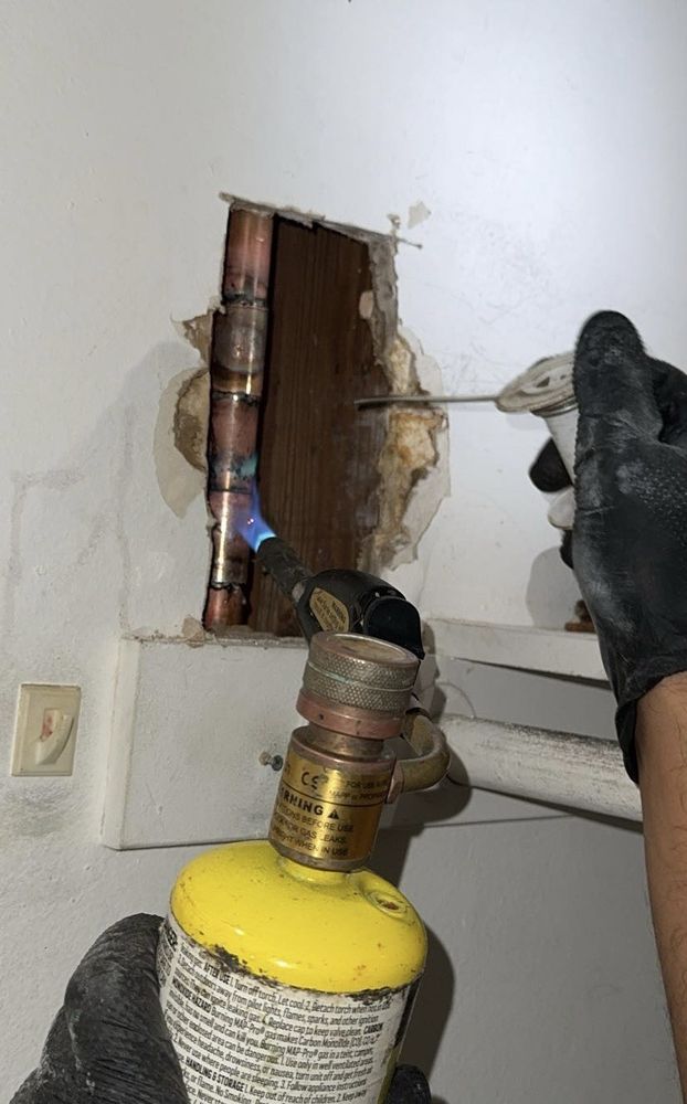 Kitchen sink with granite countertop and open cabinet below.