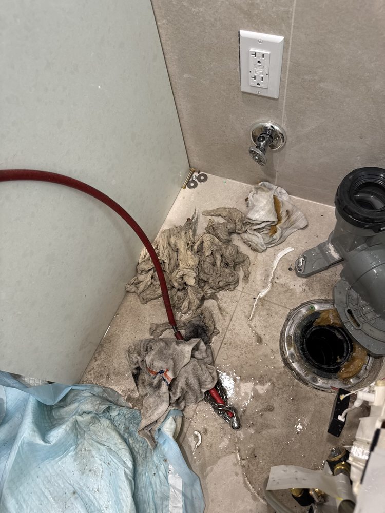 Plumber soldering copper pipes inside a wall with a torch.