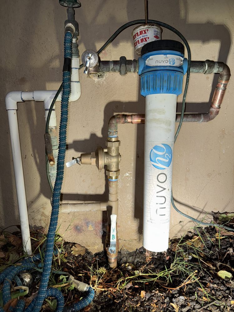 Outdoor water filtration system with pipes and a Nuvo filter housing.