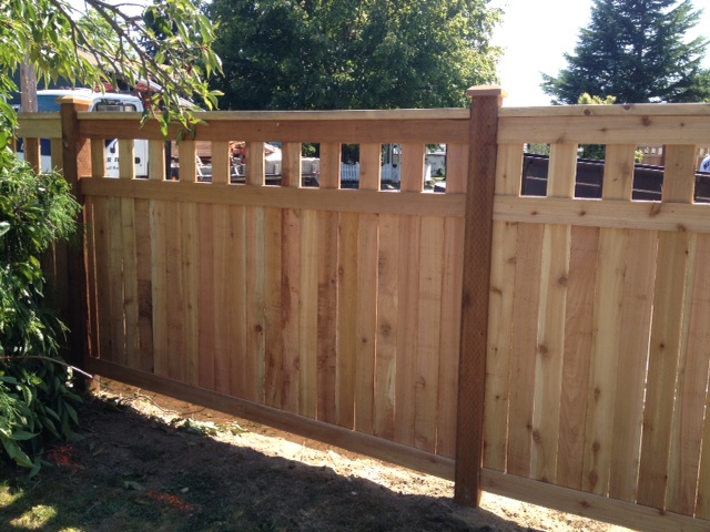 Cedar Alta-top privacy fence with decorative upper openings and capped posts near trees