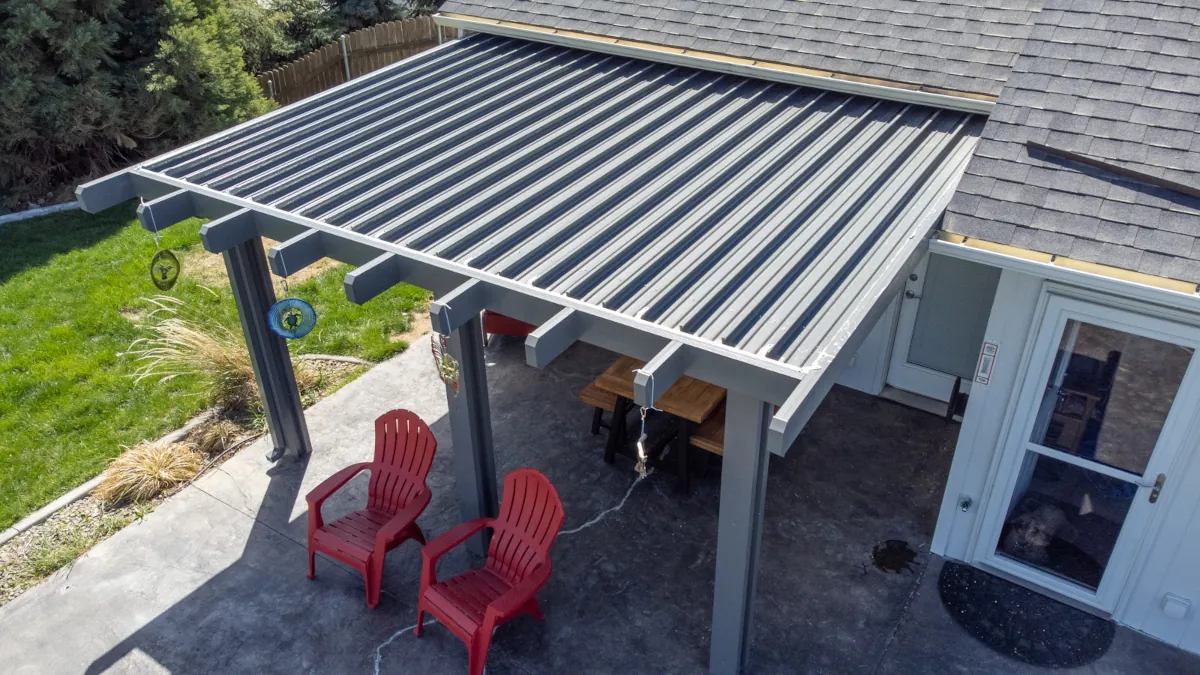 Duralum insulated aluminum patio cover with solid ribbed roof panels attached to a home