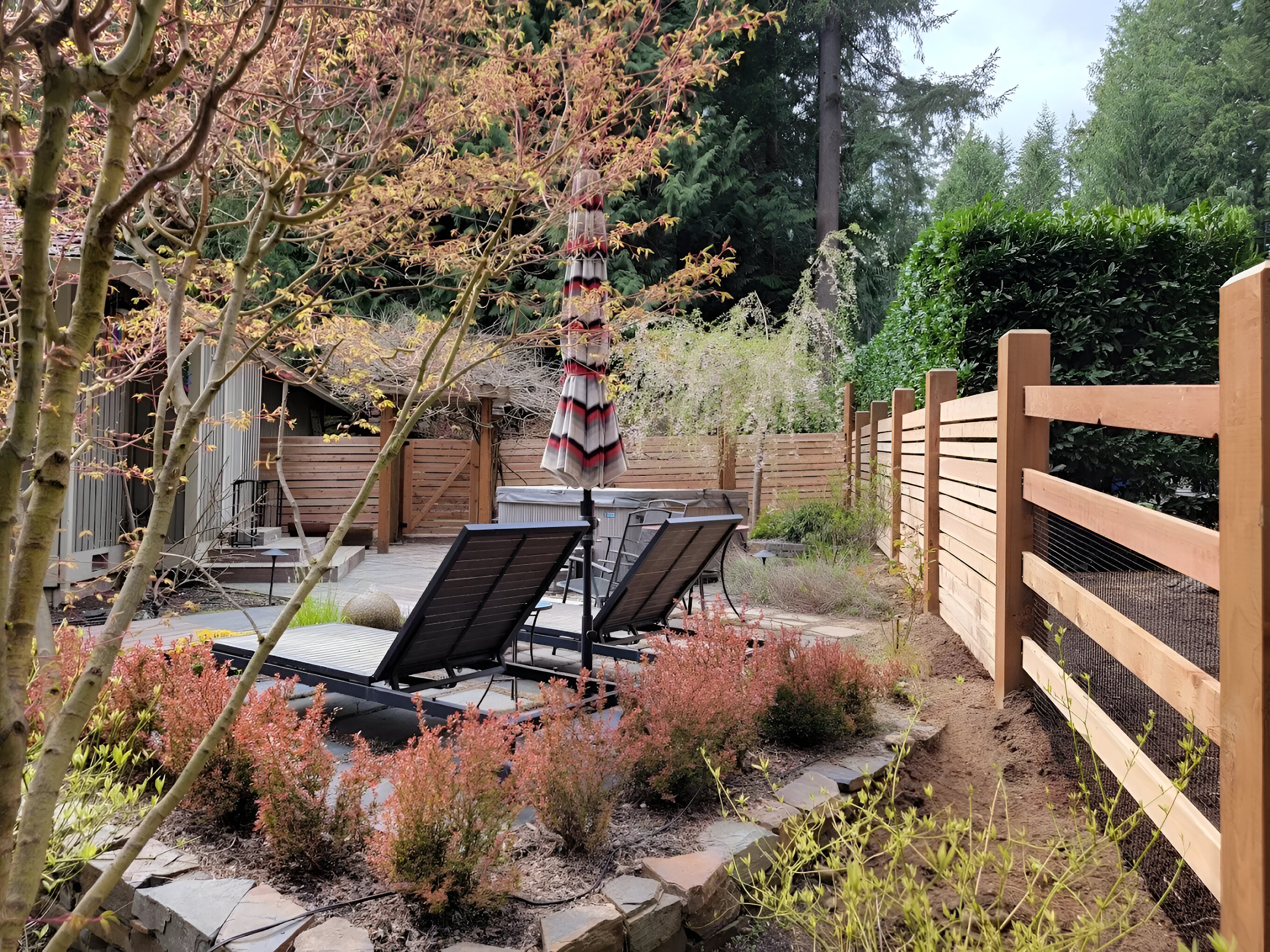 A patio enclosed by a wooden horizontal privacy fence