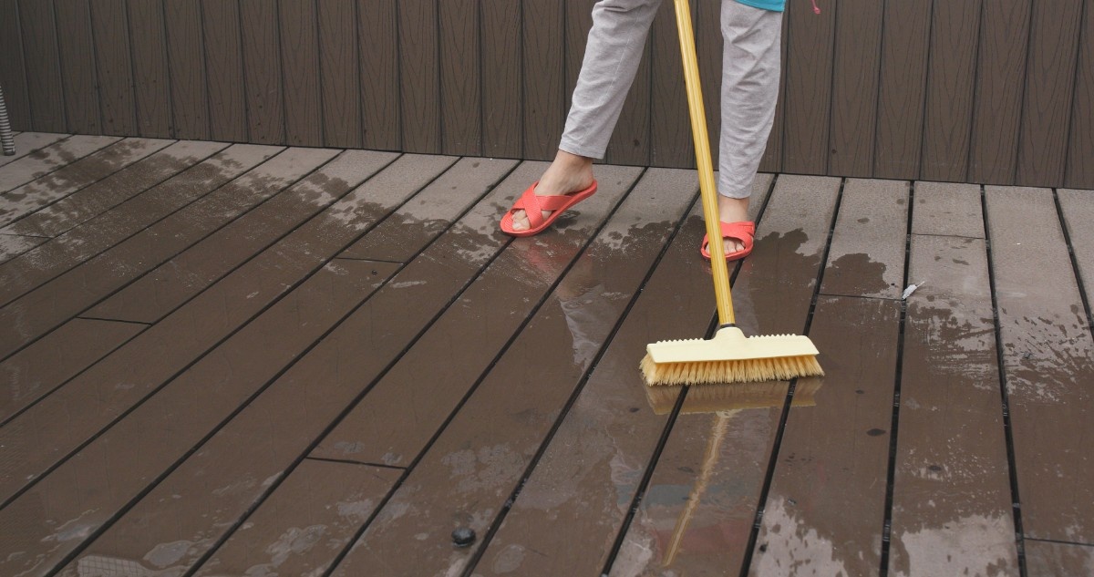 A homeowner cleaning a deck for staining in Seattle