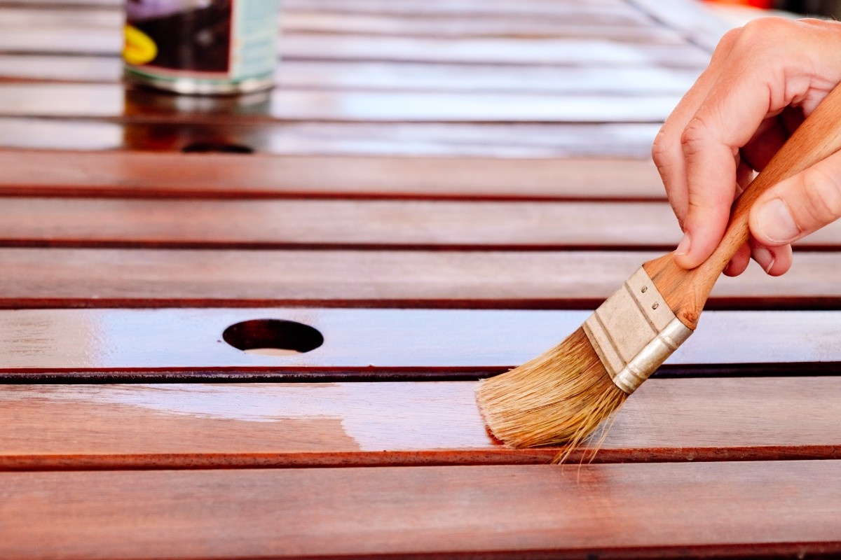 Homeowner applying stain on a deck in Seattle using brush 