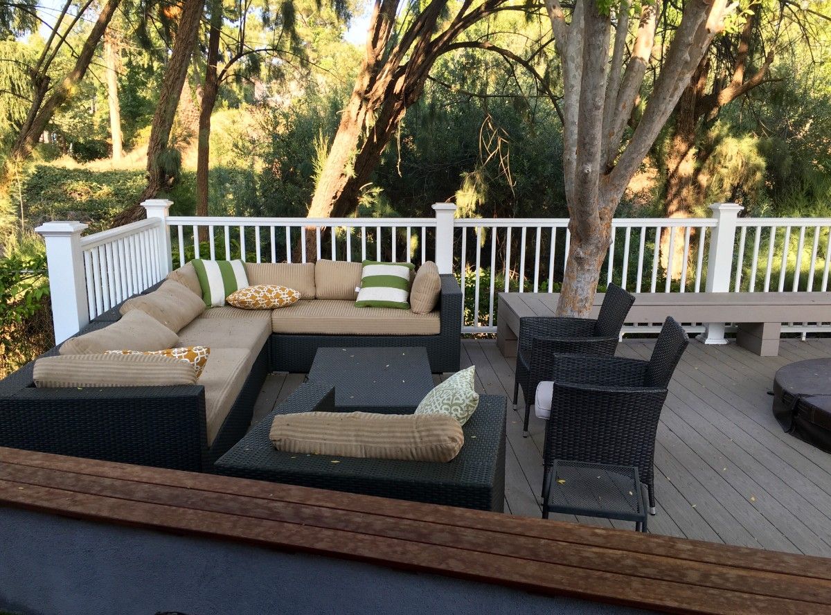 White vinyl deck railing options on a Pacific Northwest backyard deck with wicker sectional seating