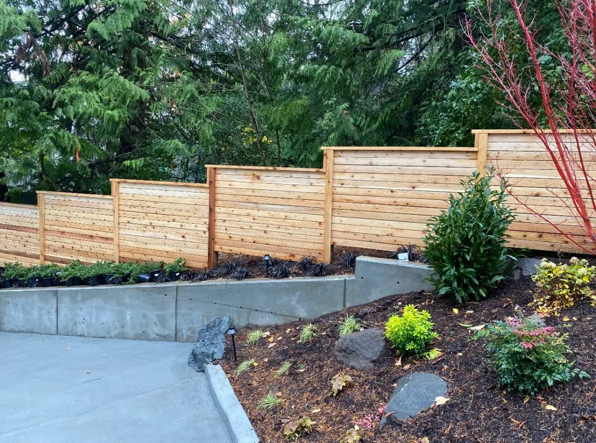 Wooden fence built on a sloped yard with plants in Greater Seattle