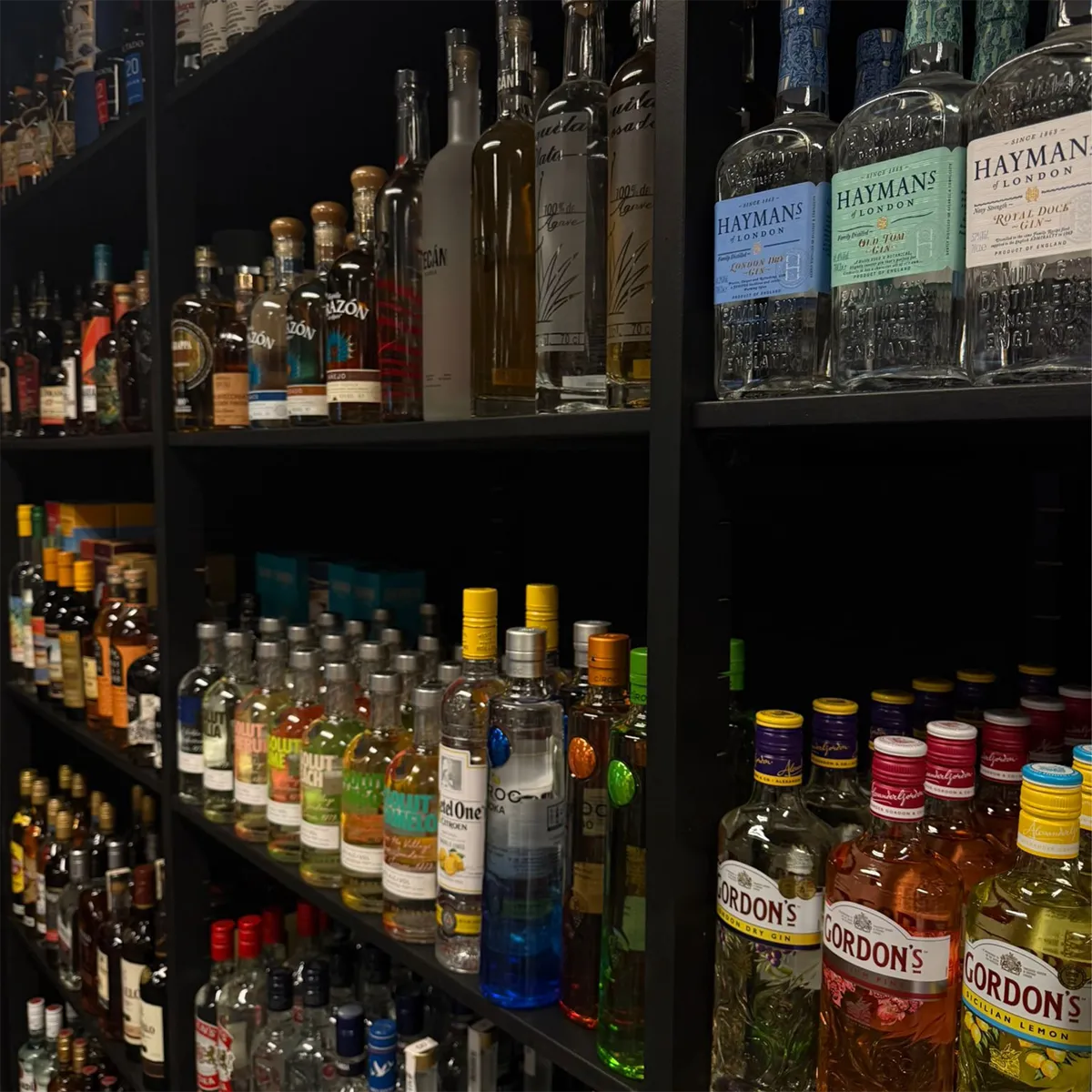 Schappen vol flessen sterke drank in slijterij De Kaaskop, met onder andere gin, vodka, rum en whisky.”