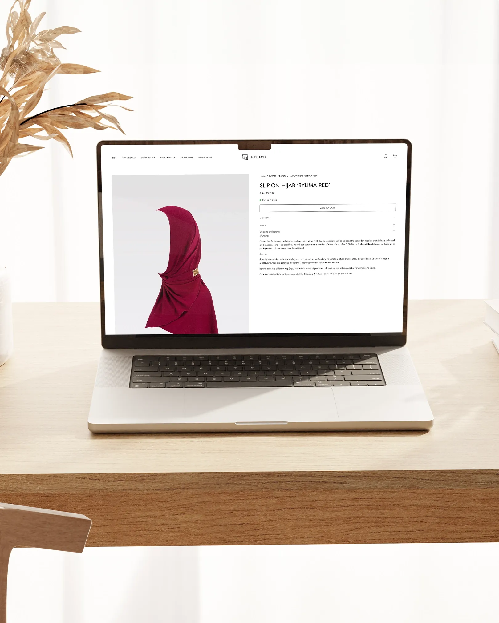 Productpagina van BYLIMA webshop met rode slip-on hijab ‘Bylima Red’ op laptopbeeldscherm.