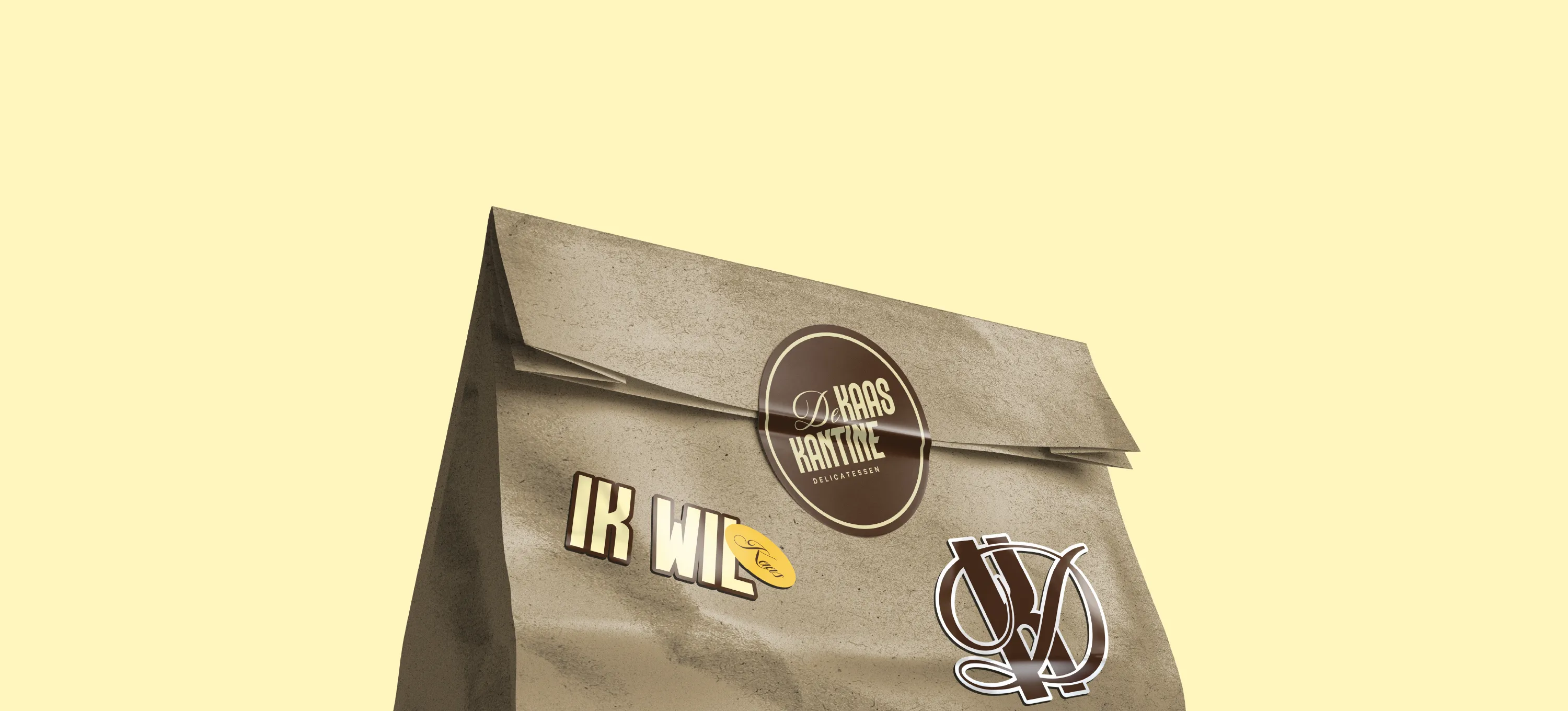Papieren zak van De Kaaskantine met logosticker, 'Ik wil kaas'-sticker en monogramsticker.