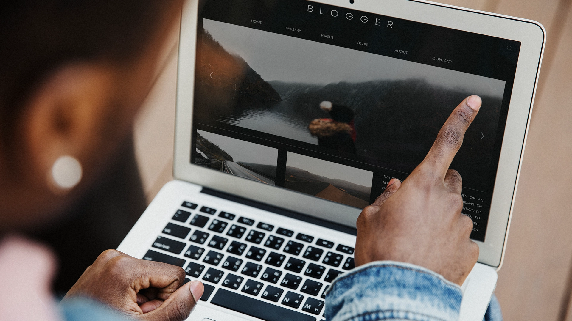 Persoon wijst naar een website op een laptopscherm, bij het artikel over waar je op moet letten bij webdesign in Twente