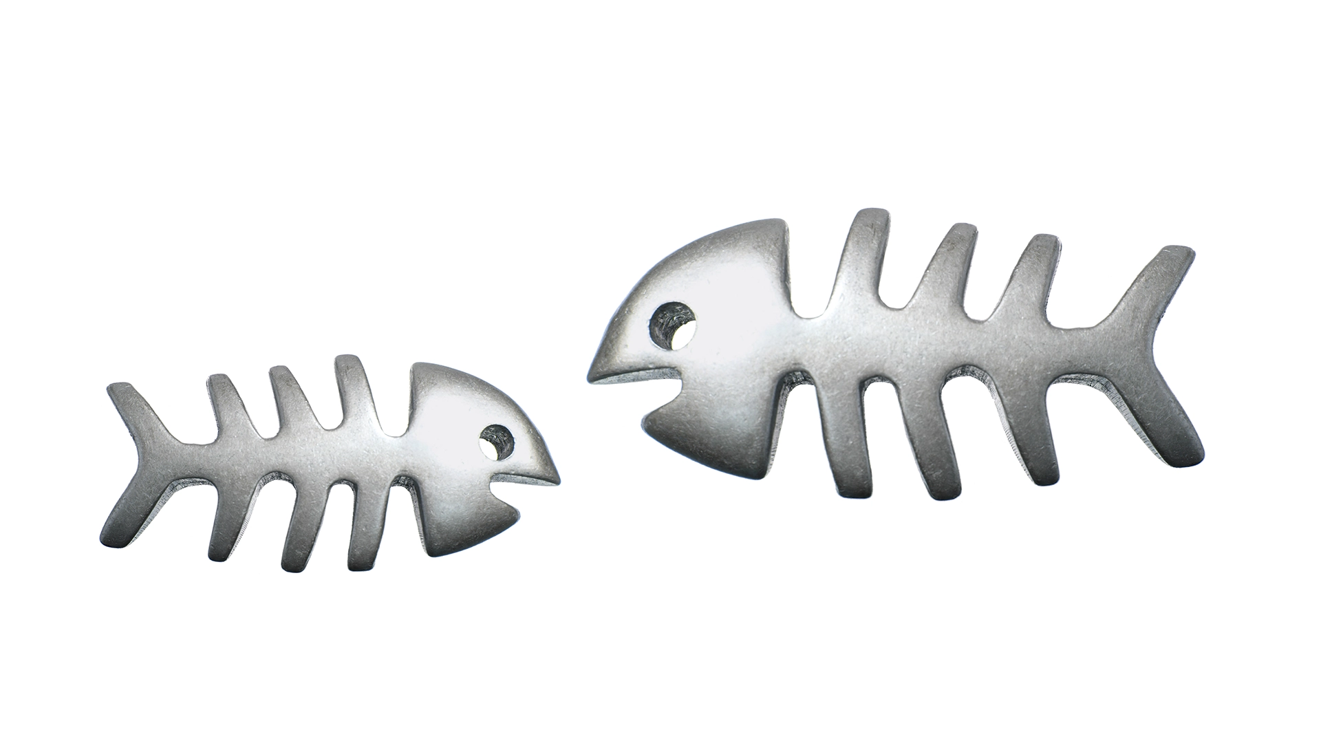 Twee metalen visgraat-vormen naast elkaar op een witte achtergrond, als beeldmetafoor voor een logo dat werkt als herkenbaar symbool