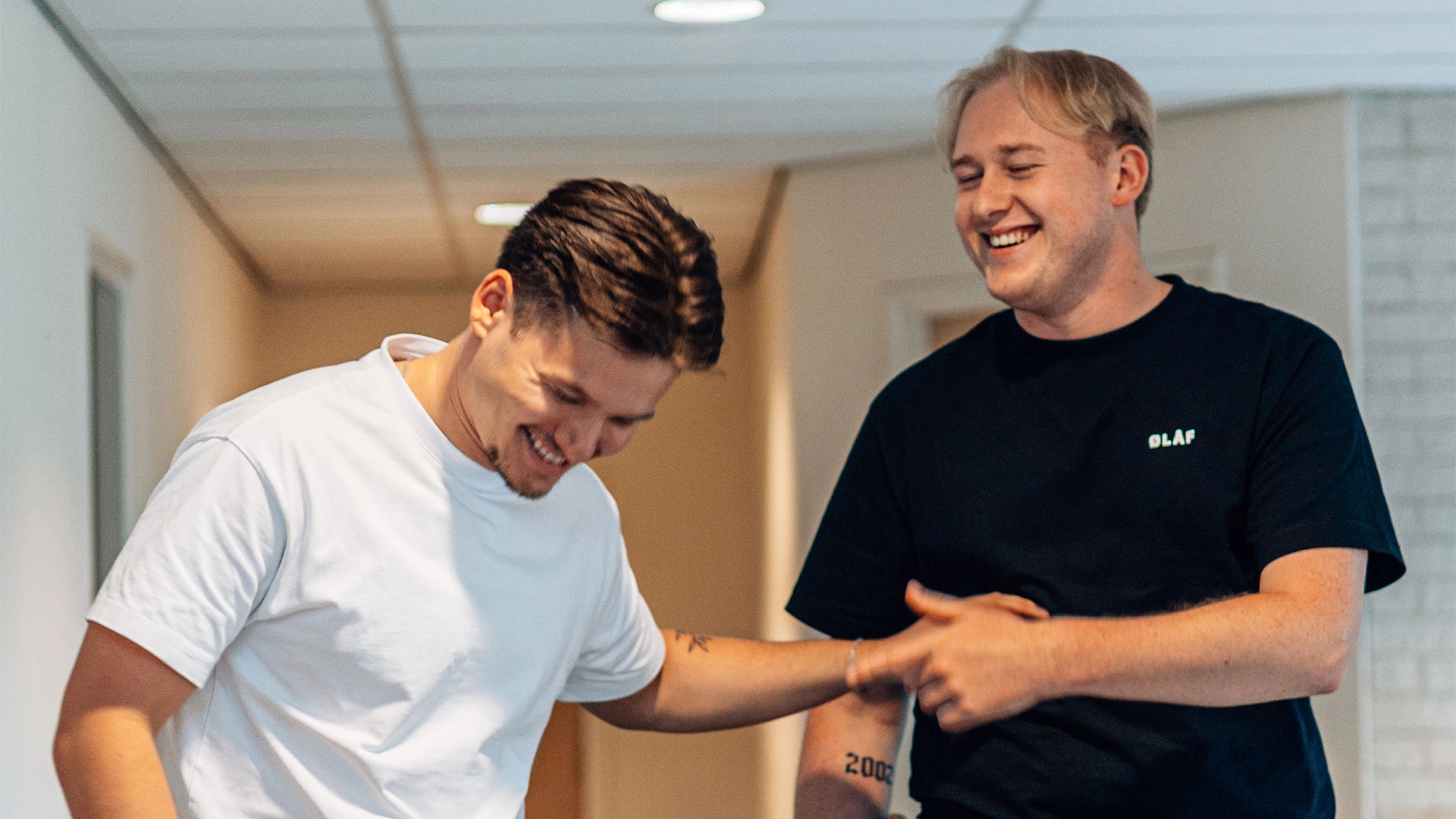 Nick Elfvering en Victor Beerkens van East Creatives lachend samen op kantoor