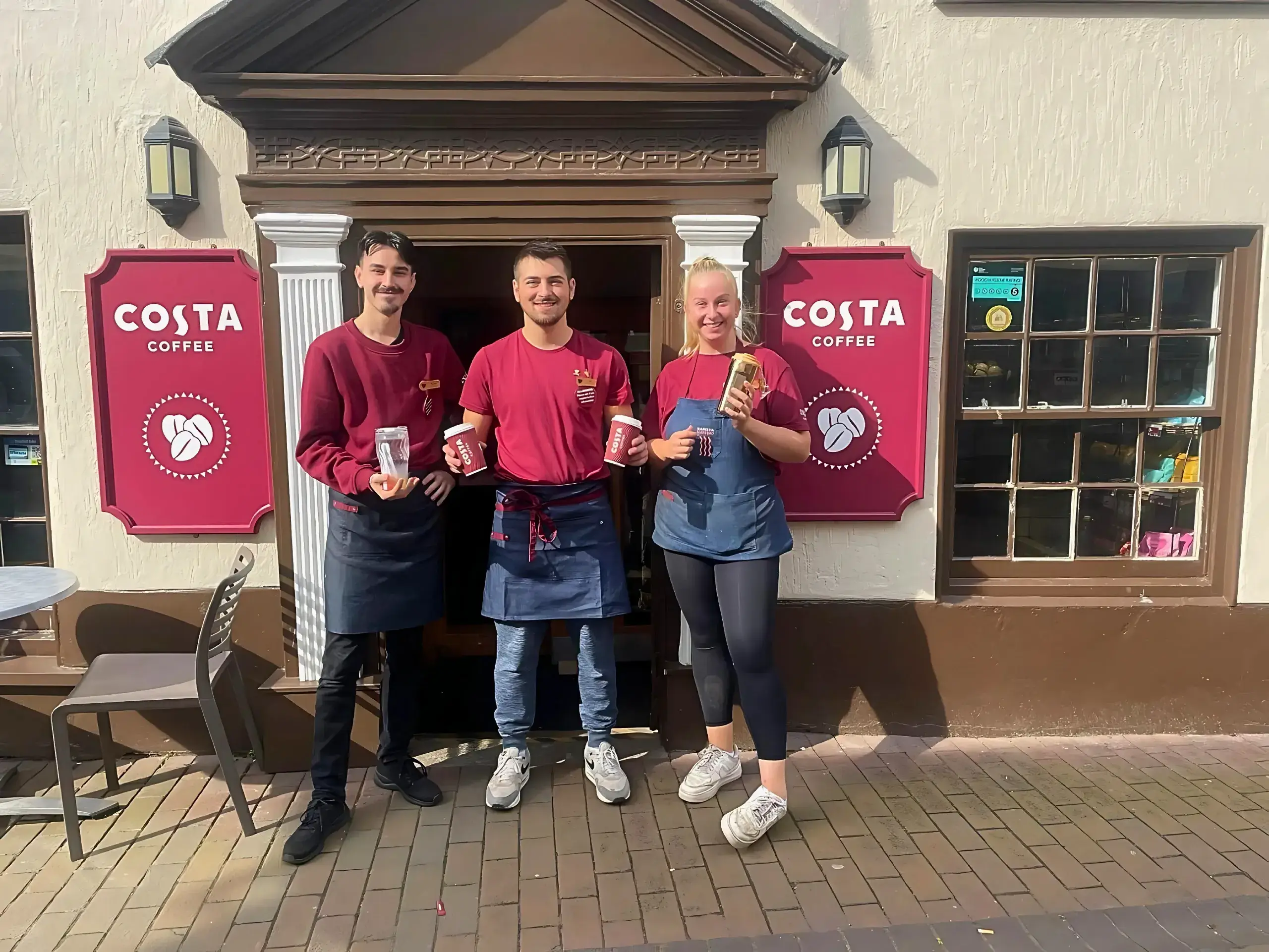 Scoffs team posing at Costa storefront