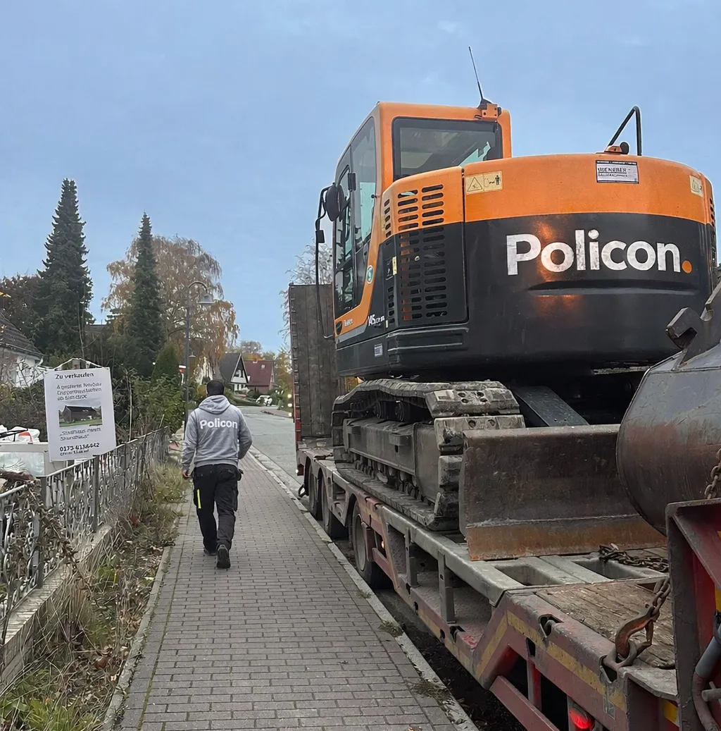 Bagger der Policon GmbH auf einem Tieflader für den Transport zu einem Bauprojekt.