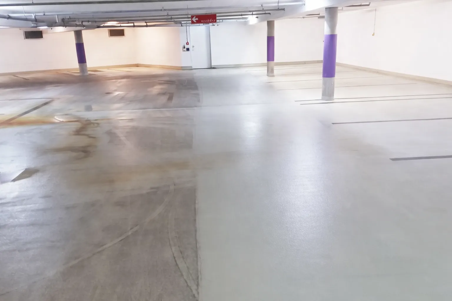 Tiefgaragenreinigung durch Policon GmbH mit gereinigten Betonbodenflächen.