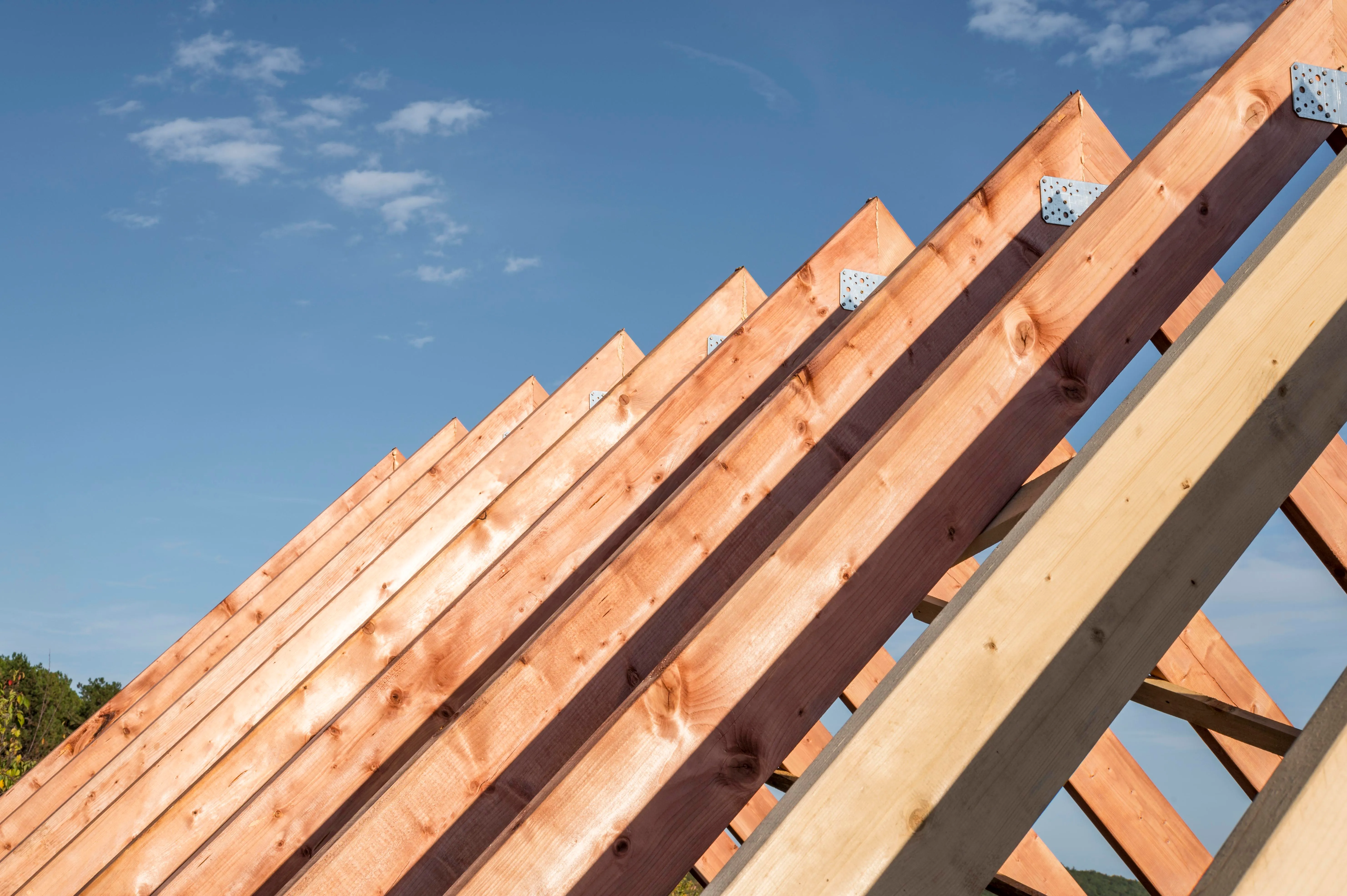 Dachstuhl aus Holz mit montierten Dachsparren während der Dachkonstruktion eines Gebäudes.